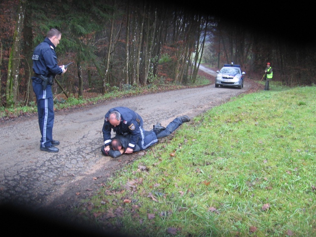 Der Täter sitzt auf dem Opfer, der bisher nicht belangte Polizistenkollege - sein Vorgesetzter - steht daneben.